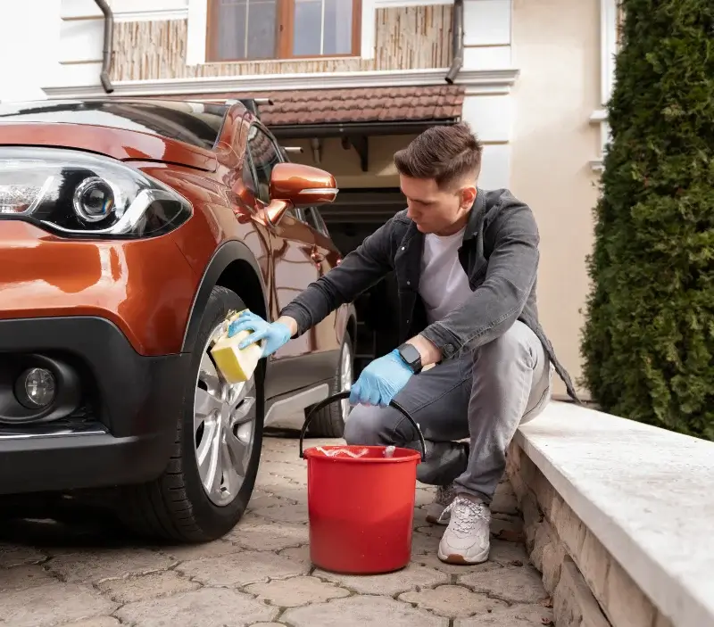 Lavage auto à domicile Ambrugeat : professionnel intervenant sur un véhicule